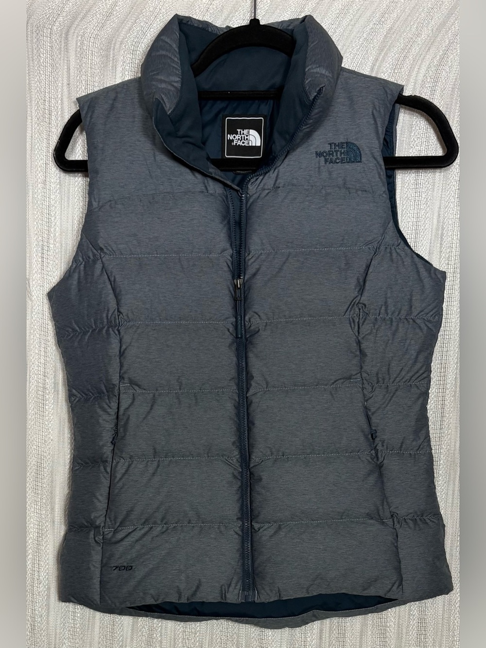 The North Face Nuptse Down Vest in a heathered dark blue or slate gray finish